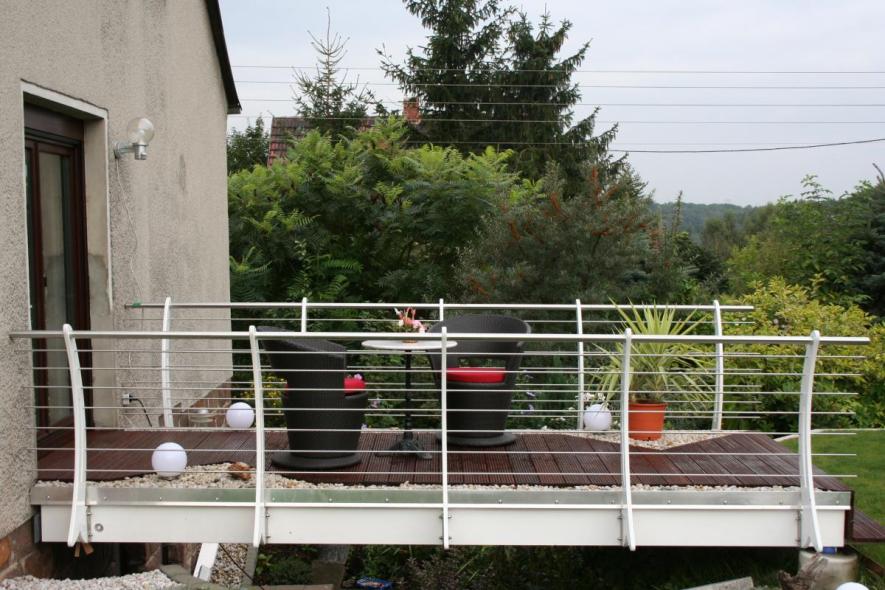 Terrasse mit dunklen Dielen und weißem Geländer